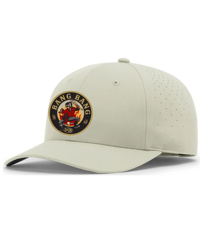 A light beige structured baseball cap with a curved brim, featuring a circular 'Bang Bang' woven patch on the front with a cartoon character holding fire fighters tools.