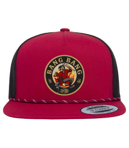 A red and black trucker hat featuring a circular 'Bang Bang' woven patch with a circular embroidered cartoon character holding fire fighter tools on the front panel.