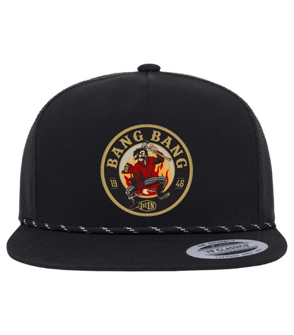 A black trucker hat with a circular woven embroidered 'Bang Bang' with a cartoon character holding fire fighter tools on the front panel. The hat has black mesh side panels, and a flat brim.